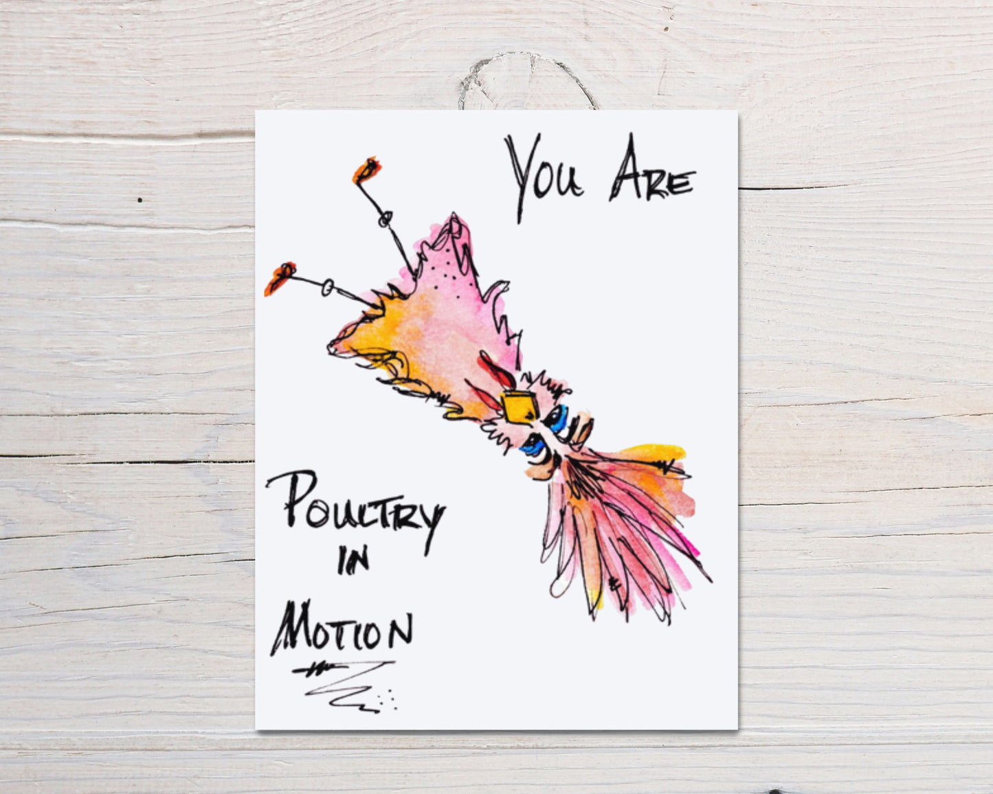 Front side of hand-drawn, hand-painted card of a colorful, whimsical watercolor upside-down bird with the works "You Are Poultry In Motion" surrounding the moving bird, on a white washed wood background